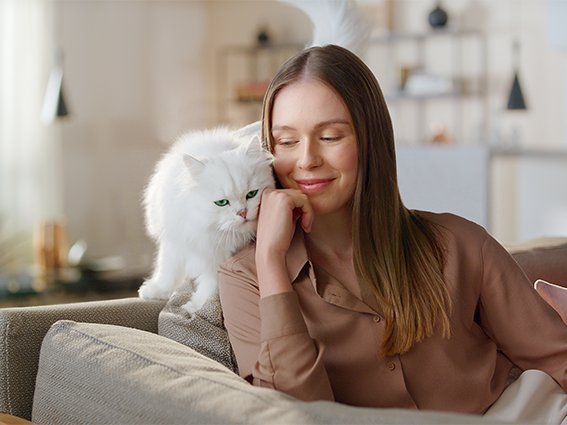 A woman and a white cat side by side